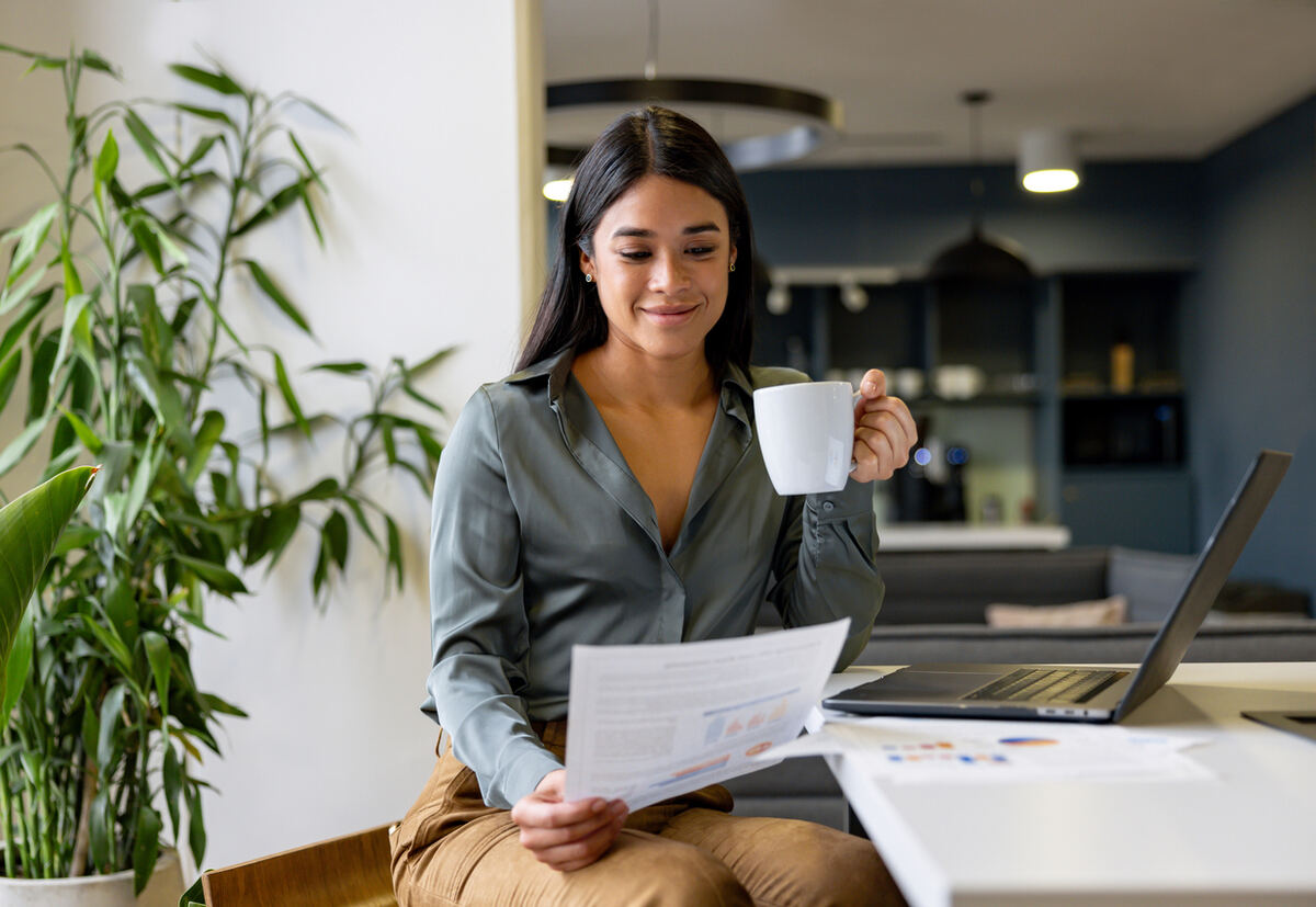 Office team member enjoying her morning coffee at work